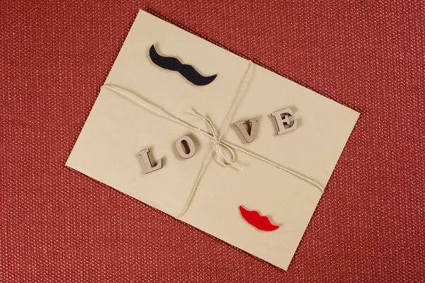 Fondo del día de San Valentín, sobre kraft marrón con la palabra amor, con una cuerda kraft . — Foto de Stock