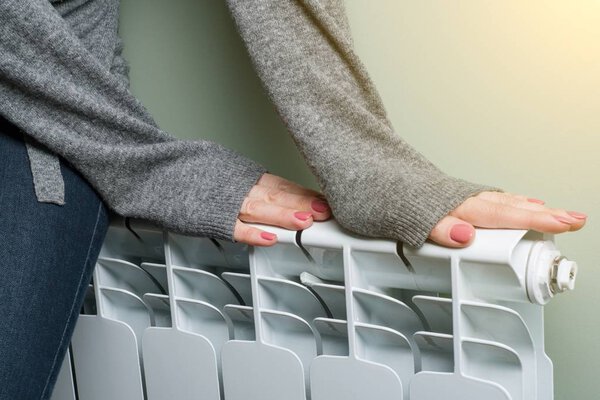 Woman put her hands on the radiator