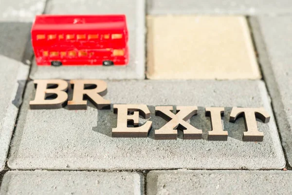 Storbritannien utträde ur Europeiska unionen, Brexit ordet abstrakt i vintage bokstäver, bakgrund double decker buss leksak modell. — Stockfoto