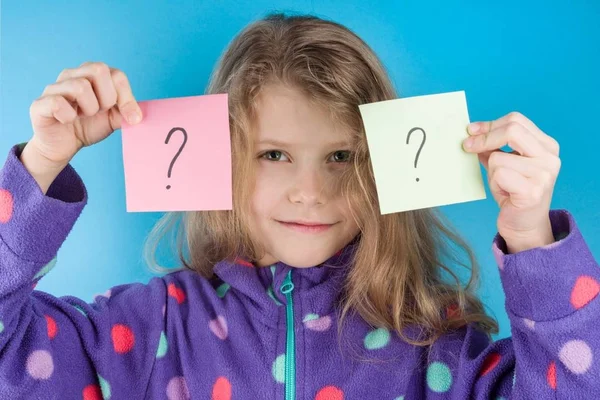 Niña sosteniendo pegatinas con signos de interrogación — Foto de Stock