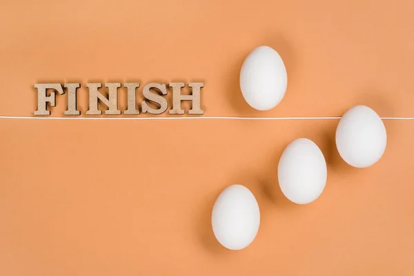 Abstract image. Egg behind the a finish line — Stock Photo, Image