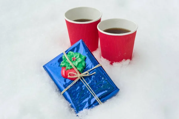 Prezent, tło zima - śnieg, dwie filiżanki kawy. — Zdjęcie stockowe