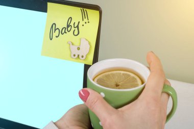 Bir kadından bir bilgisayarda Word bebek bir kağıt etiket sıkışmış.