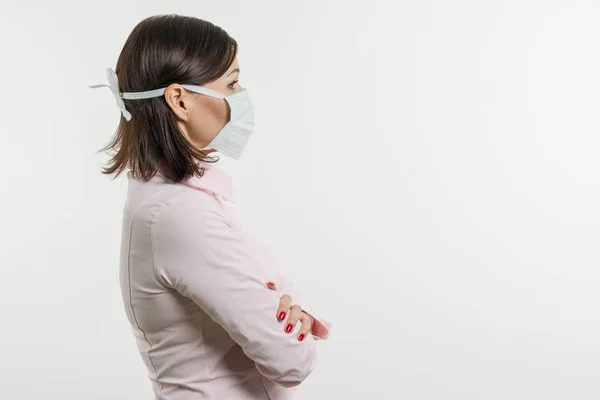Женщина в медицинской маске, смотрит на профиль — стоковое фото
