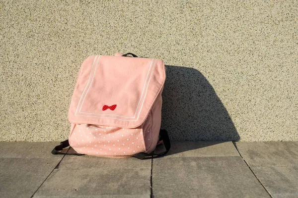 Una colegiala de mochila. Fondo gris pared solar —  Fotos de Stock