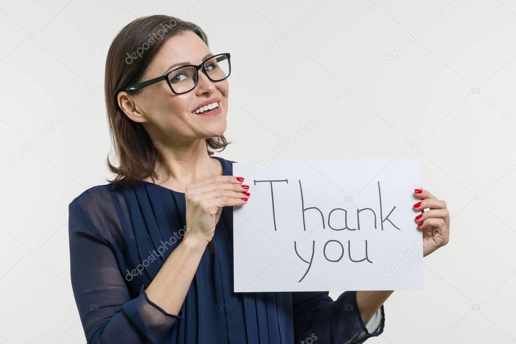 Happy businesswoman showing thanks. Holds the paper with the text thank you.