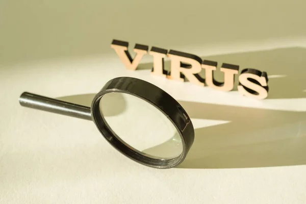 Förstoringsglas på vit bakgrund med ordet Virus — Stockfoto