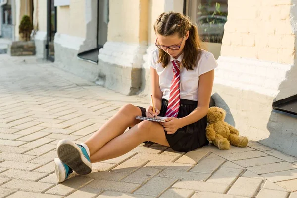 Schoolmeisje tiener schrijft in een notitieblok. Dagboek meisjes — Stockfoto