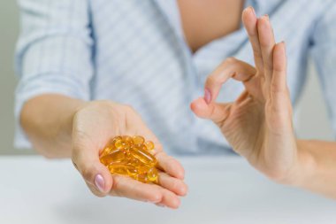 Omega 3 kapsül ve bir işaret tutan kadının el Tamam