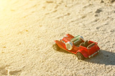 Cabriolet oyuncak retro otomobil modeli kumlu yol arka plan üzerinde.