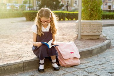 Genç kız öğrenci okuma bir kitap, kentsel tarzı