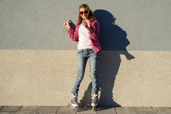 Portrait of young cool girl, shod in rollerblades holding chocol — Stock Photo, Image