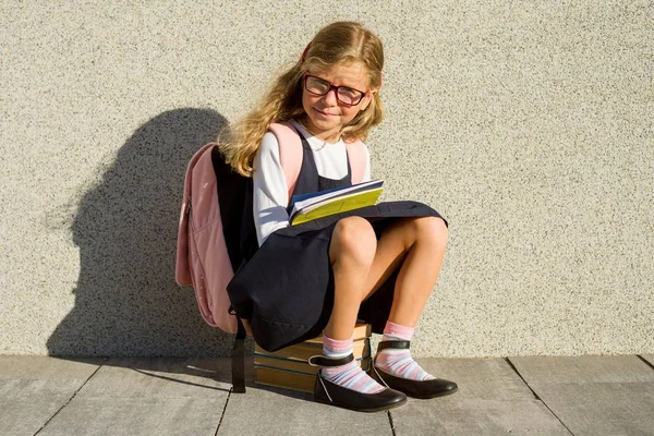 Um estudante do ensino fundamental com cadernos na mão . — Fotografia de Stock