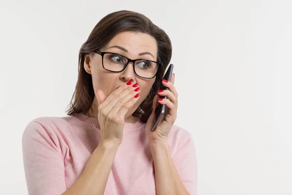 Portrait of a woman tells secrets and gossip on the phone. — Stock Photo, Image