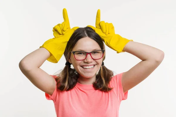 Девочка-подросток в жёлтых защитных перчатках. Белый фон, время уборки — стоковое фото