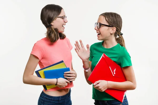 Amicizia di due adolescenti. Su uno sfondo bianco, le ragazze parlano e ridono — Foto Stock