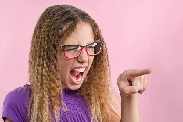 Una adolescente gesticula emocionalmente, señala un dedo hacia un lado . — Foto de Stock