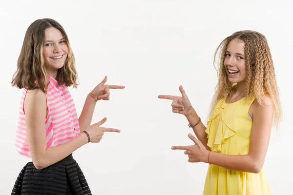 Attractive positive two teenage girls pointing her index finger away — Stock Photo, Image