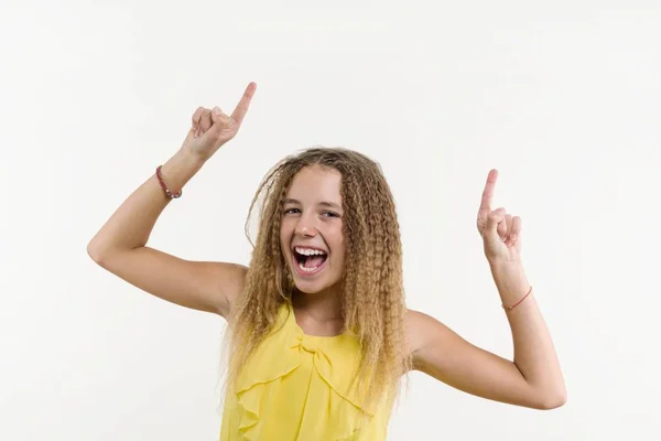 Rubia feliz con el pelo rizado, adolescente apuntando con el dedo índice hacia arriba —  Fotos de Stock