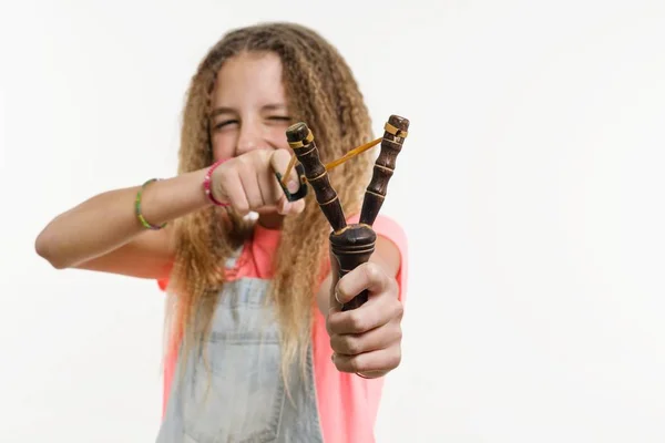 Stout meisje met krullend haar tiener houdt een katapult. — Stockfoto