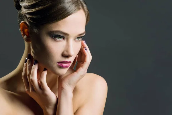 Mujer joven con maquillaje de noche. Cabello oscuro y hombros desnudos, cogidos de la mano cerca de la cara, mirar hacia otro lado . — Foto de Stock