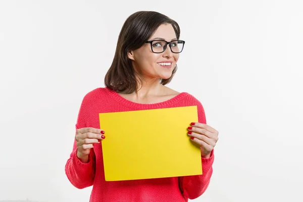 Uśmiecha się w środku wieku kobieta z żółtej kartce papieru — Zdjęcie stockowe