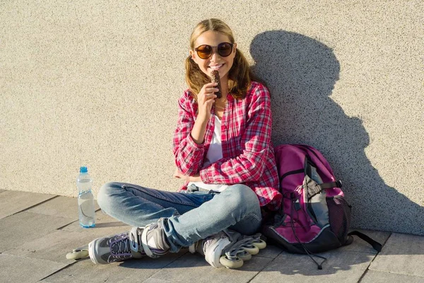 Menina adolescente bonita calçado em rolos leva chocolate — Fotografia de Stock