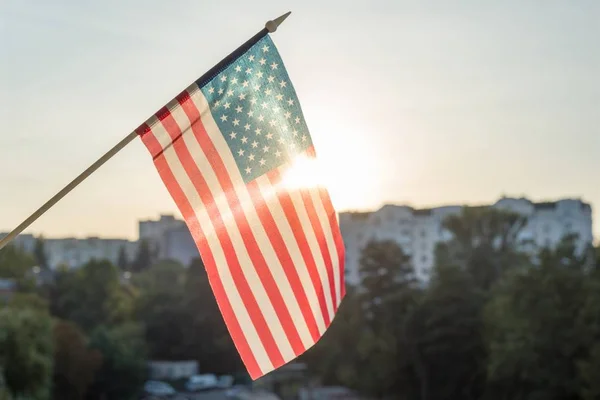 American flag from the window, on sunset background