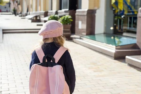 Niña con estilo con mochila, en un abrigo y boina francesa correr a la escuela. Vista trasera — Foto de Stock