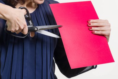 Bir kadın makas ve bir parça kağıt, kesik kağıt tutar. Beyaz arka plan.