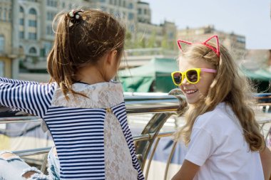 İletişim ve iki kız çocuk rahatla. Bir şehir arka plan üzerinde