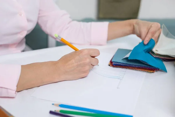 Interior designer draws at desk in office with pencil — Stock Photo, Image