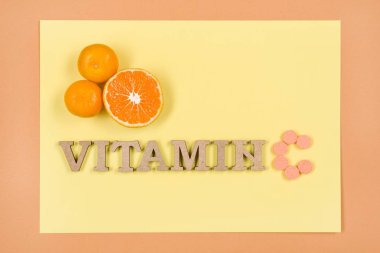 Word C vitamini ahşap harflerle yazılmış. Arka plan sarı, c vitamini, narenciye