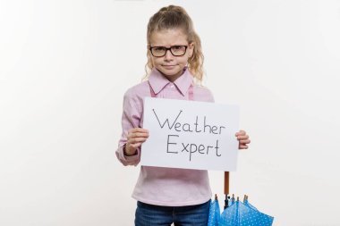 Girl child holding piece of paper with a word WEATHER EXPERT. White bakgrounde, copy space clipart