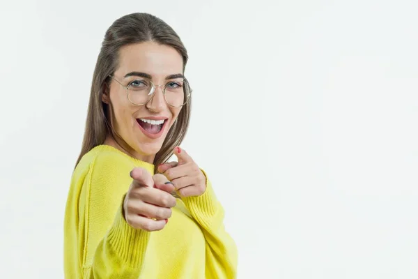 Young smiling emotional woman points at you. White background, copy space — Stock Photo, Image