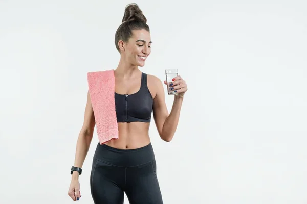Positiv leende fitness kvinna dricksvatten mot en vit ba — Stockfoto