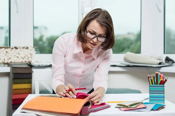 Mujer interiorista, trabaja con muestras de telas para cortinas y persianas. Empresas - Industria textil — Foto de Stock