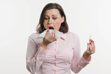Hasta işkadını holding bir mendil ve burun spreyi. Beyaz arka plan