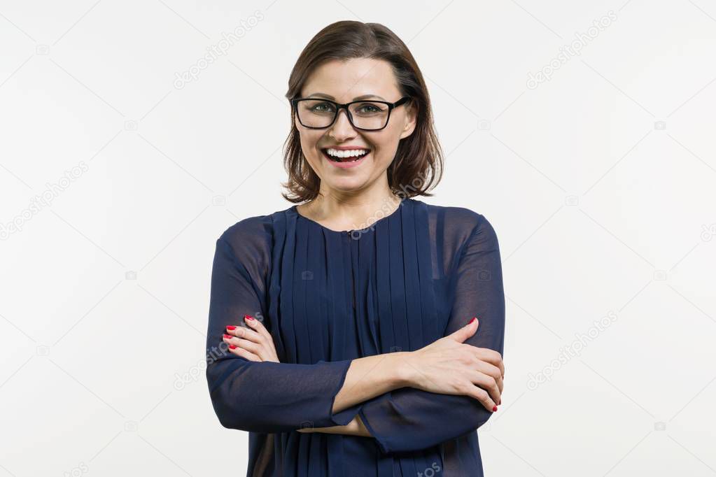 Smiling middle aged woman with folded arms on white background
