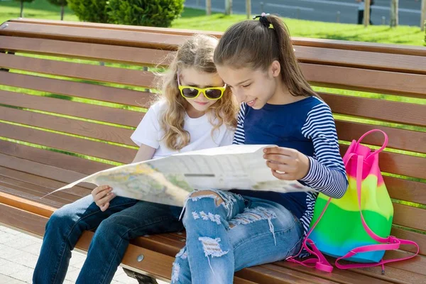 Retrato al aire libre niños turistas. Con mapa de la ciudad en el banco — Foto de Stock