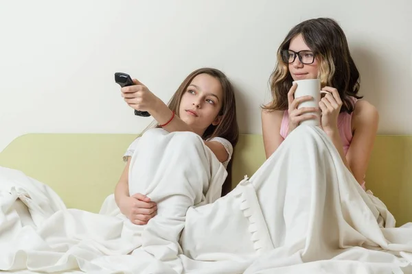 Meisjes tieners zitten thuis in bed en Tv kijken. — Stockfoto