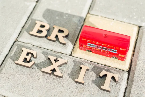 Bkyiv, Ua, 17.11.2017 Storbritannien utgång från Europeiska unionen, Brexit ordet abstrakt i vintage bokstäver, bakgrund double decker buss leksak modell — Stockfoto