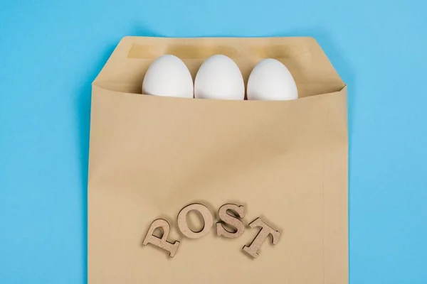 The concept of secure courier service, reliable postal company. Abstract image of eggs in an envelope and the word mail, post. — Stock Photo, Image