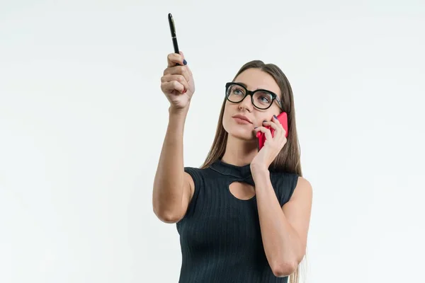 Деловая женщина в очках черное платье с телефонными точками с ручкой на копировальном месте. Студия белого фона . — стоковое фото