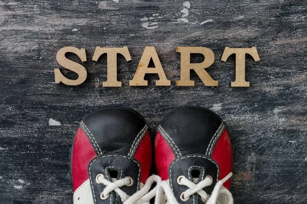 Sneakers before the word start. Dark background — Stock Photo, Image