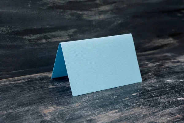 Blue blank card on table. Dark background — Stock Photo, Image