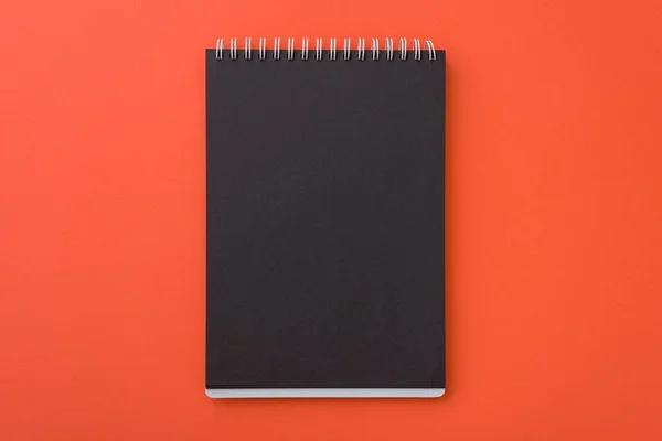 Visão superior do caderno preto em branco espiral aberto l no fundo da mesa laranja, Lugar para o seu texto — Fotografia de Stock