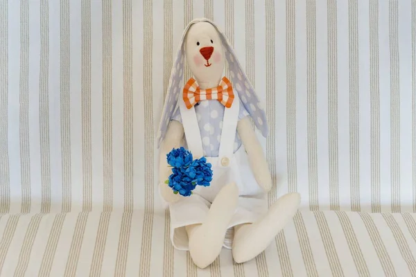 Easter Bunny Rabbit, Hand Maid Toy. On a light striped background