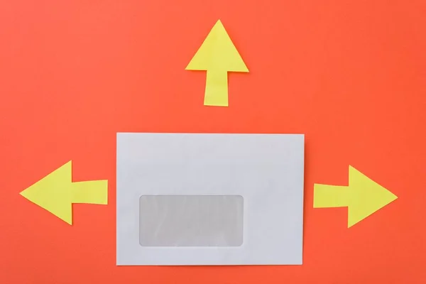 Envelope with arrows in different directions, orange background — Stock Photo, Image
