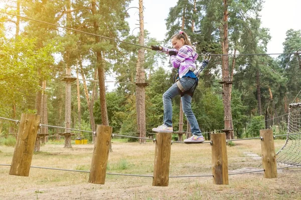 La ragazza ha 10 anni in avventura arrampicata high wire park, stile di vita attivo dei bambini — Foto Stock